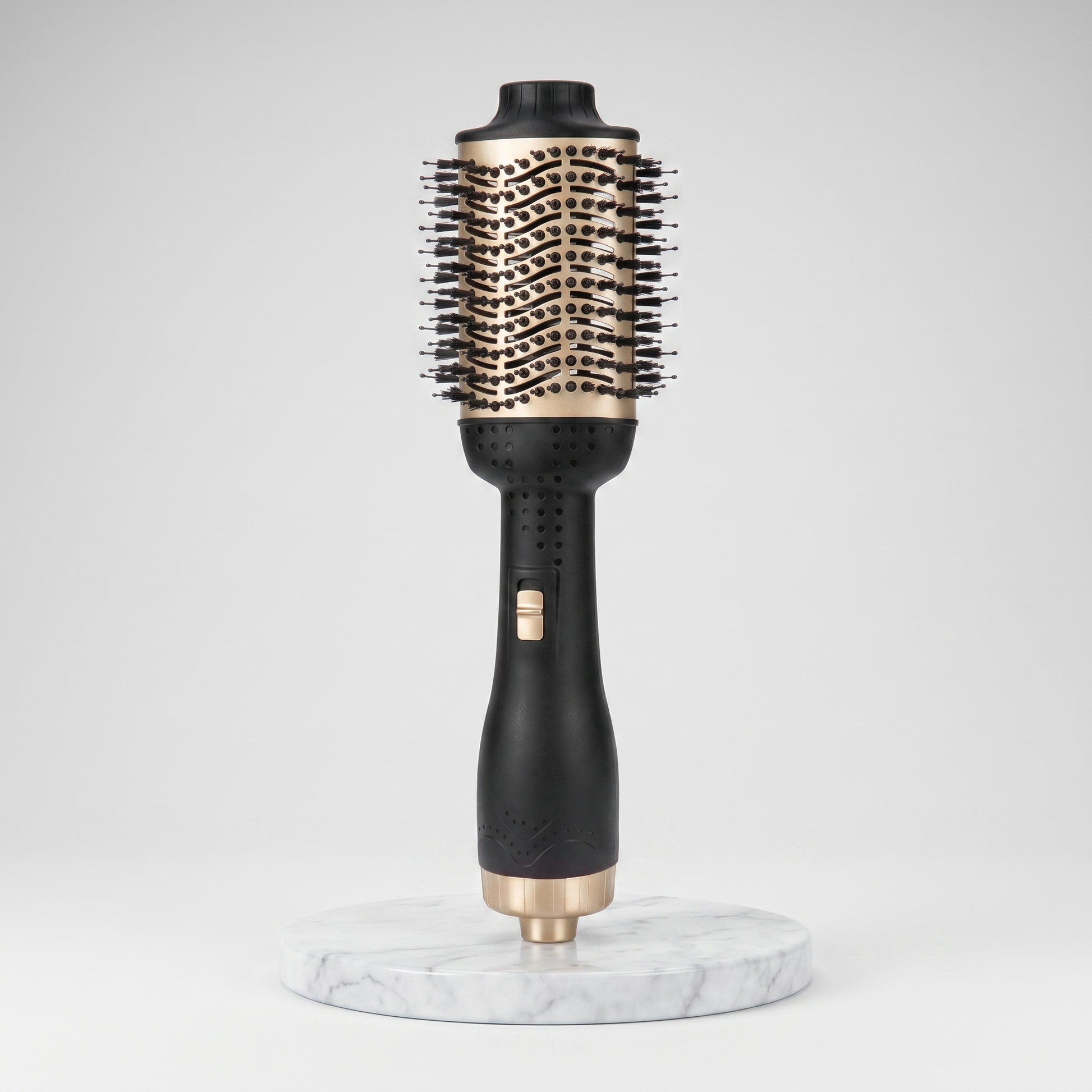 Hot air brush anti-frizz straightener in black and gold on a marble pedestal